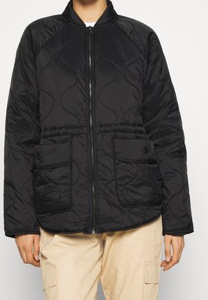 Zwarte gevoerde jas met een rits aan de voorkant, ronde kraag, twee drukknoopzakken en een gestructureerd patroon. Heeft een ontspannen pasvorm en een lichtgewicht stof.