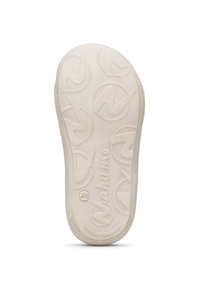 Sulan på en beige sko med texturerade cirkulära mönster, ordet "Naturino" och storlek "20" synligt på undersidan.