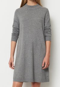 Abito grigio lavorato a maglia con un collo alto, maniche lunghe, polsini a costine e una vestibilità morbida, che cade appena sopra il ginocchio. Tessuto soffice.