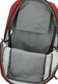 Zaino rosso aperto per mostrare il compartimento principale vuoto con rivestimento interno grigio e scomparto imbottito per laptop.