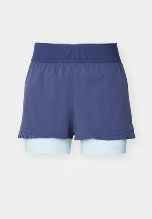 Shorts de sport bleu marine avec une taille côtelée et un ourlet plissé, superposés à des shorts de vélo bleu clair pour plus de couverture.
