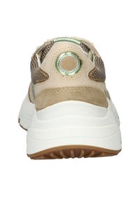 Beige Sneaker mit einem Obermaterial aus Mesh und Wildleder, einem runden grünen Akzent an der Ferse und einer strukturierten weißen Gummisohle mit braunem Profil.