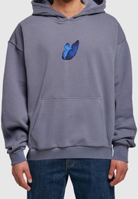 Sudadera con capucha de tela gris, que presenta un gráfico de mariposa azul en el pecho, con un bolsillo frontal tipo canguro y puños de canalé.