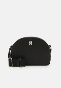 Borsa a tracolla nera realizzata in materiale morbido, presenta una parte superiore arrotondata, hardware dorato e una tracolla regolabile con un design testurizzato.