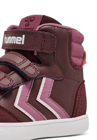 Höga sneakers i vinröd och rosa läder som har två vita zigzag-accenter, kardborreband och en texturerad tygkrage.