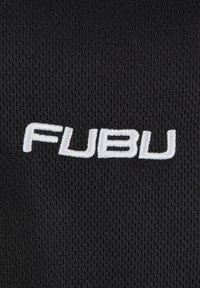 Schwarzer Stoff mit einem strukturierten Muster, das das weiße gestickte Logo "FUBU" in einer fetten, serifenlosen Schriftart deutlich zeigt.