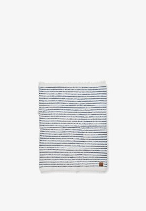 Stribet tæppe i hvid og marineblå, med en blød tekstur, frynsekant og et lille brunt lædermærke i hjørnet.