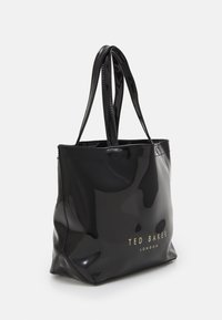 Czarna torebka z lakierowanej skóry z dwiema rączkami i płaskim dnem. Z przodu znajduje się złote logo "TED BAKER LONDON". Gładka, błyszcz�ąca tekstura.
