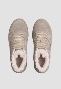 Sneakers beige in pelle scamosciata con superfici testurizzate, punte rotonde e fodera soffice color crema intorno al collo, con lacci beige e logo.