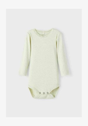 Combinaison à manches longues de couleur vert clair en tissu côtelé, avec un col en dentelle et une fermeture à boutons-pression au bas. Douce et texturée.