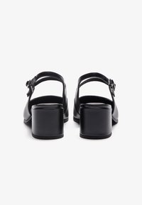 Sorte hæl sandaler med en glat læderoverdel, ankelstrop med spænde detalje og chunky firkantede hæle.