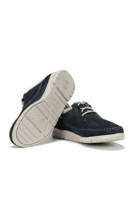 Scarpe in suede blu navy con suola in gomma bianca, caratterizzate da un design perforato, dettagli cuciti e chiusura con lacci.