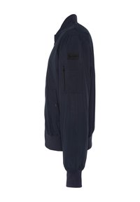 Chaqueta bomber de color navy con un bolsillo con cremallera en la manga izquierda, puños y dobladillo acanalados, confeccionada con un tejido ligero y de textura suave.