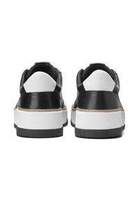 Ein Paar schwarz-weiße Plateausneaker, von hinten gezeigt, mit dicken weißen Sohlen und schwarzen Außensohlen.