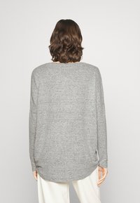 Gray, long-sleeve sweater with a rounded hem and soft texture, featuring a relaxed fit and a simple, minimalist design.