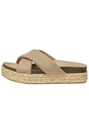 Beige slip-on sandal med brede krydsede stropper og tyk vævet platformsål til afslappet brug.