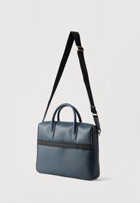 Μπλε δερμάτινη θήκη με διπλές λαβές, ρυθμιζόμενη μαύρη ζώνη και οριζόντια μαύρη λεπτομέρεια μπροστά. Απαλή υφή.