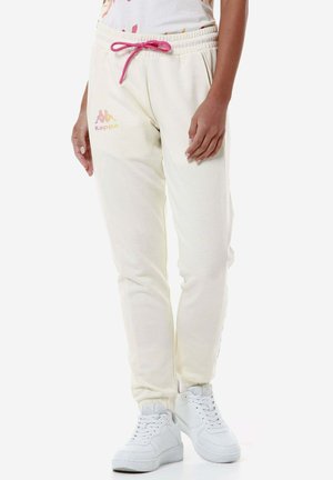 Pantaloni jogger color crema con elastico in vita e lacci rosa. Caratterizzati dal logo Kappa in pastello sulla coscia sinistra. Polsini a coste.