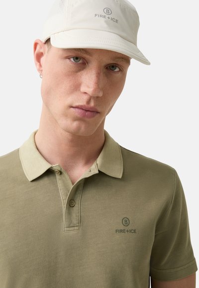 Olive green polo shirt with textured fabric, two buttons at the collar, featuring a subtle logo "FIRE + ICE" in darker green. White cap worn above.