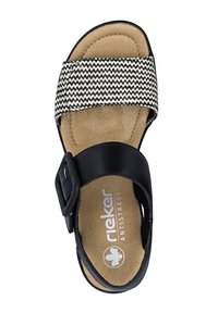 Rieker Antistress sandaal met zwarte verstelbare band en zwart-wit zigzag stof voorband op een beige gevoerde zool.