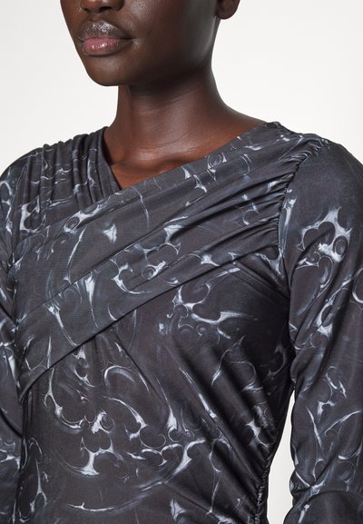 Čierne šaty s abstraktnými šedými a bielymi vzormi, s drapovaným výstrihom a zhromaždením pozdĺž ramien a bokov.