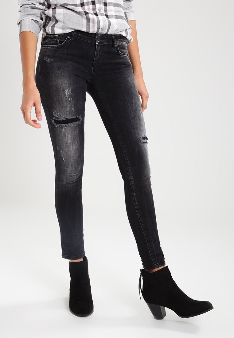 Jean skinny noir avec un design déchiré aux genoux. Fabriqué en denim, il offre une silhouette ajustée et une texture délavée.