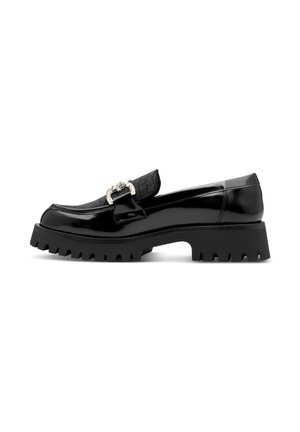 Mocassin en cuir noir brillant avec semelle crantée épaisse, dessus texturé et boucle décorative argentée vue de côté.