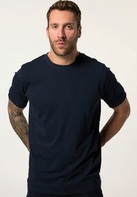Námořnická modrá bavlněná tričko s klasickým kulatým výstřhem, krátkými rukávy a hladkou texturou. Žádné viditelné vzory ani kovové detaily.