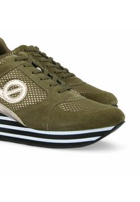 Olijfgroene sportschoenen met suède en mesh details, voorzien van een wit logo, een zwart-witte gestreepte zool en een ronde neus.