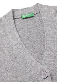 Šedý pletený cardigan s výstřihem do V, se jedním kulatým knoflíkem, jemnou texturou a zelenou etiketou s nápisem "UNITED COLORS OF BENETTON."