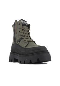 Bottines en toile vertes avec semelle en caoutchouc noir, fermeture à lacets à l'avant, zip sur le côté et détails texturés. Semelle épaisse et robuste pour une bonne adhérence.
