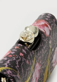 Clutch bag com padrão floral em pele texturizada preta, com fecho em forma de rosa em tom dourado. Apresenta detalhes florais em rosa e roxo.