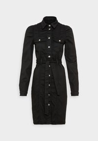 Svart denimklänning med krage, långa ärmar, fyra framfickor och midjerem. Har synliga knapppdetaljer och sömmar.