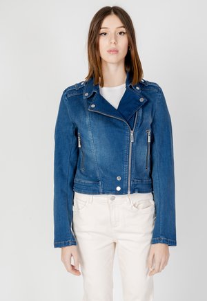 Veste en denim bleu raccourcie avec un col en revers, des fermetures éclair en métal et des détails de boutons. Elle possède deux poches zippées à l'avant et des manches longues.