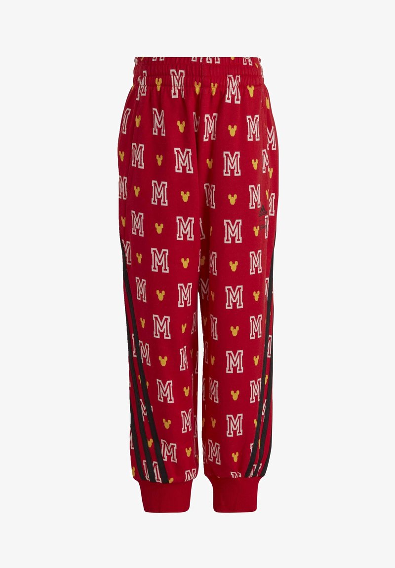 Pantalones de chándal rojos con un estampado de letras "M" blancas y cabezas de Mickey Mouse amarillas en toda la superficie, con franjas laterales negras y puños elásticos.