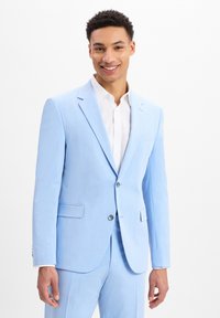 Lichtblauwe suit met een gestructureerde afwerking, twee zijzakken en een enkele knoopsluiting. Gekocht over een wit shirt met een slim fit ontwerp.