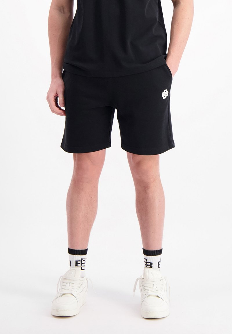 Zwarte shorts gemaakt van een katoenen mengstof met een elastische tailleband en zijzakken. Witte logo-detail op de linkerdij.