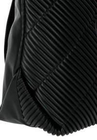 Zwarte gewatteerde handtas met een geribbelde textuur, gladde randen en een zacht materiaal. Het ontwerp heeft uitgesproken stiksels en rondingen.