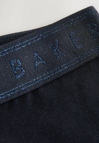 Ceinture en tissu noir avec lettres en relief "BAKER" en fil bleu foncé ; elle présente une texture lisse et un léger éclat.