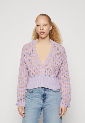 Lilla strikket cardigan med åpenmønster, med oransje striper, V-hals og kort passform. Inkluderer knapper foran.