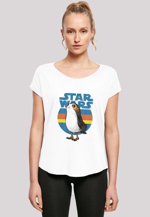 Hvit T-skjorte med kort erm som har en tegneserieaktig fugleillustrasjon og "STAR WARS"-tekst i blått, med en sirkulær fargebakgrunn.