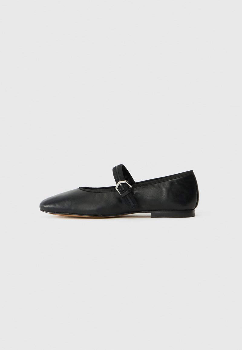 Ballerine in pelle nera con punta appuntita, cinturino con dettagli a fibbia e suola bassa e piatta. Texture liscia con elementi di design minimi.