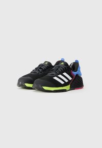 Black athletic shoes with white stripes, textured mesh upper, colorful accents in blue, red, and neon green, and a rubber sole.