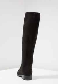 Czarne zamszowe botki do kolan o gładkiej fakturze, zaokrąglonym nosku i niskim obcasie. Projekt charakteryzuje się bezszwowymi cholewkami i minimalnym szyciem.