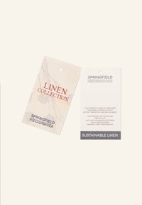 Étiquettes en lin avec "COLLECTION LIN" en rouge et "LIN DURABLE" en gris. Papier doux, texturé, blanc cassé avec des trous circulaires.