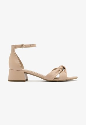 Naga skórzana sandały z knotywnym paskiem, zamkniętym tyłem i średnim obcasem blokowym, z płaską podeszwą i zapięciem na kostkę.