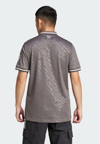 Polo grigio con un sottile motivo geometrico, maniche corte e colletto con accenti a righe bianche e nere.