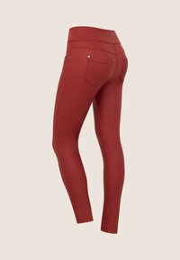 Leggings rossi a vita alta con una texture liscia e elastica. Presentano tasche posteriori con hardware minimale e un design elegante e aderente.