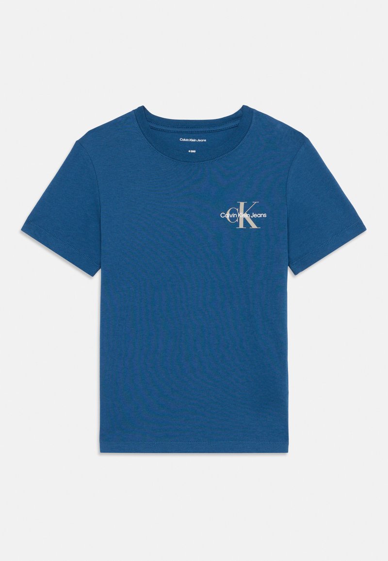 Tričko s krátkým rukávem a kulatým výstřihem v jednobarevné modré bavlně se malým bílým logem "Calvin Klein Jeans" na hrudi. Hladká textura.