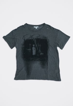 T-shirt gris foncé à manches courtes avec un graphisme noir délavé représentant une personne entre deux croix, et de légers trous usés près de l'encolure et de l'ourlet.